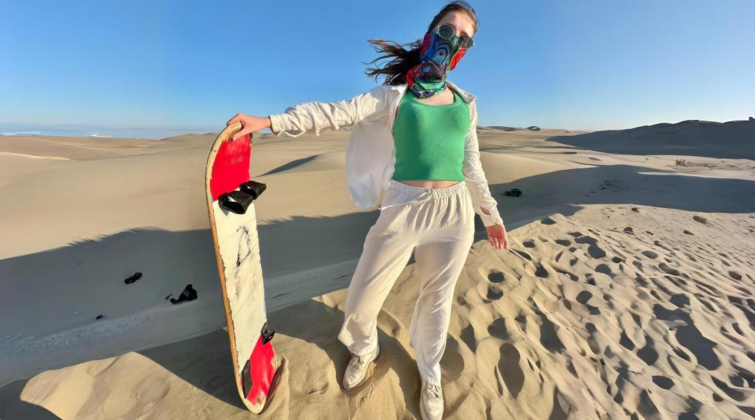 Sandboarding down golden dunes in Peru